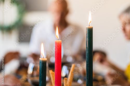 Bright wax candles with shiny flame on table during festive event on blurred background with bokeh effect