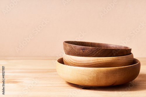 Empty wooden bowls of various shapes on bright studio background