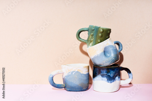 Still life of handmade ceramic mugs on bright studio background