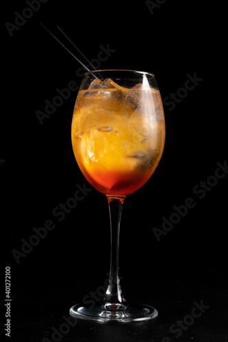 Alcohol cocktail Fiero spritz. Low alcohol cocktail of martini, gin tonic, orange and ice in a transparent glass on a black background.