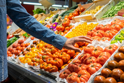 Cropped unrecognizable male customer choosing fresh groceries while buying food in supermarket