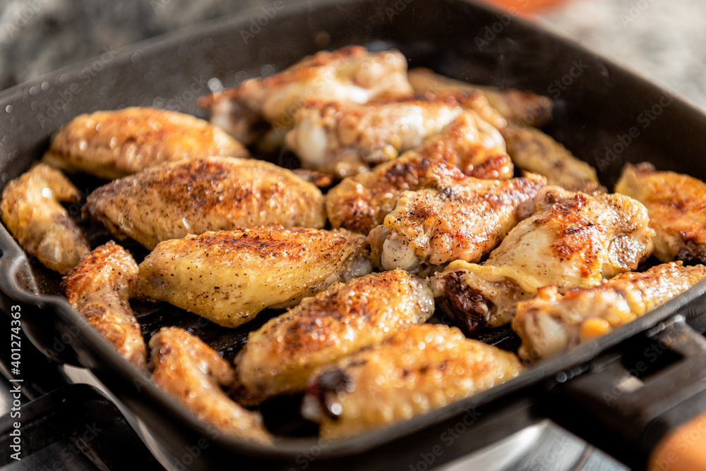 Closeup of hot freshly roasted chicken with appetizing crust in frying pan in kitchen Closeup of hot freshly roasted chicken with appetizing crust in frying pan in kitchen