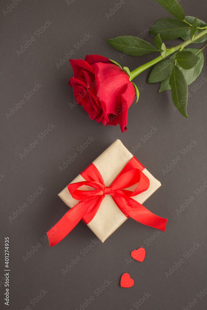 Top view of red rose, gift and hearts on the black background Top view of red rose, gift and hearts on the black background