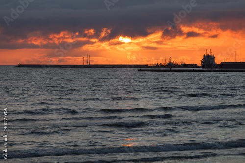 Dramatic sunset sky over the sea and the pier.