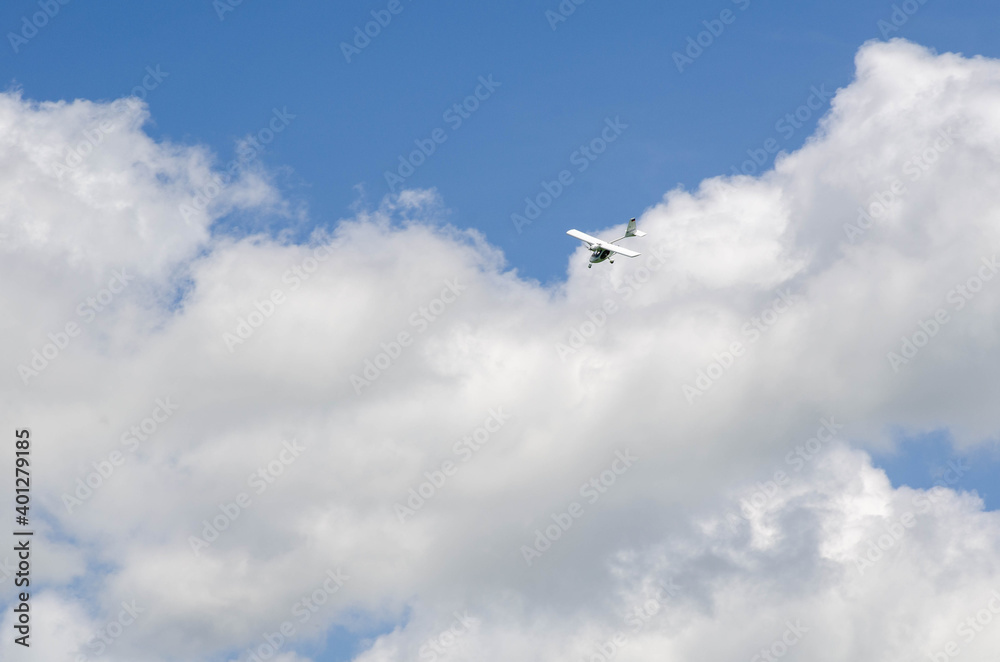 Small aircraft plane soars, flies in the sky among the clouds Small aircraft plane soars, flies in the sky among the clouds