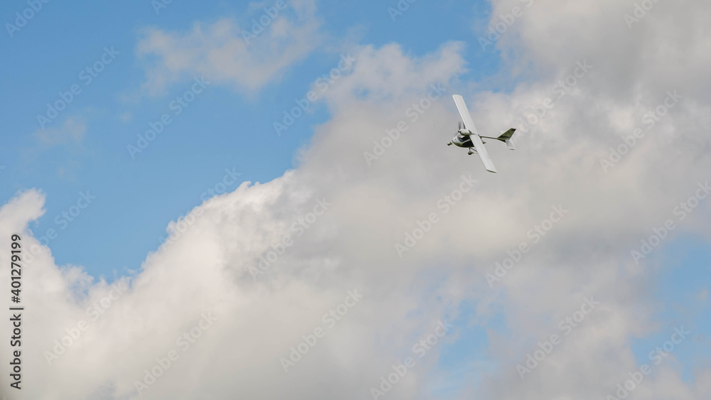 Small aircraft plane soars, flies in the sky among the clouds