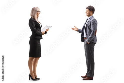 Blond businesswoman holding a document and talking to a young professional man