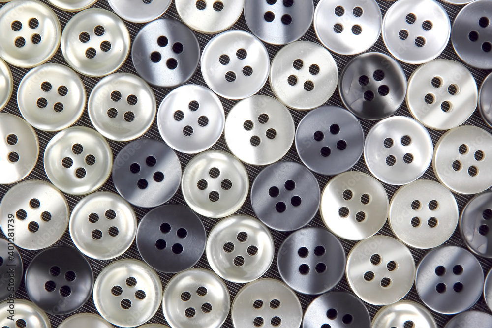 Plastic shiny buttons for clothes on a fabric background. Fashion and clothing. Factory industry Plastic shiny buttons for clothes on a fabric background. Fashion and clothing. Factory industry