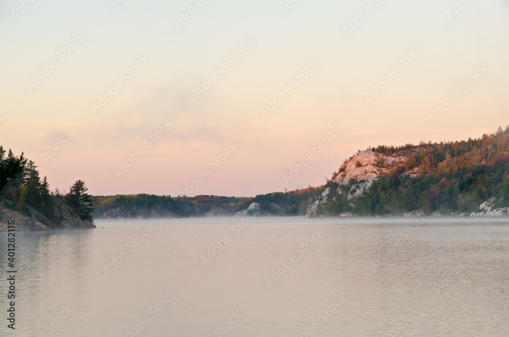 Sunrise above forest lake