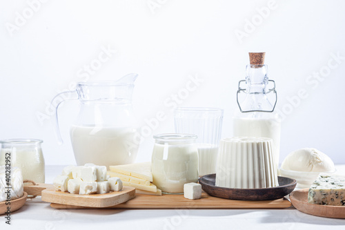 Dairy products in glass recipients and wooden dishes on  white background.