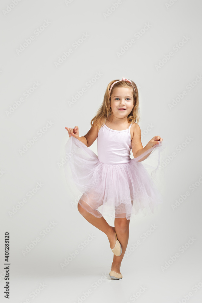 Naklejka premium cute little child girl dreams of becoming a ballerina. ballet dancer in pink tutu