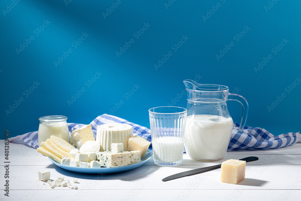 Dairy products on white wood base and blue background. - obrazy, fototapety, plakaty 