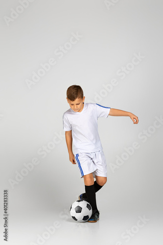Fototapeta Naklejka Na Ścianę i Meble -  little child boy playing with soccer ball over studio background.