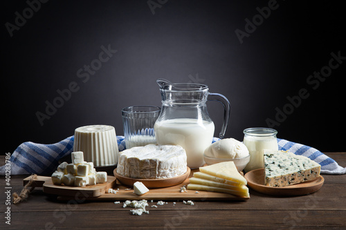 Dairy products on wooden base and dark background with copy space.