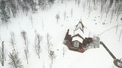 view of the old wooden church standing in the park in winter