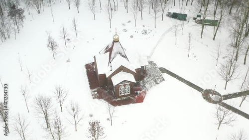 view of the old wooden church standing in the park in winter