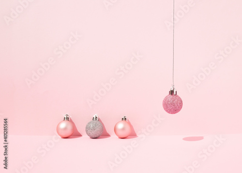 From above of decorative Christmas baubles arranged on pink background in studio for holiday celebration