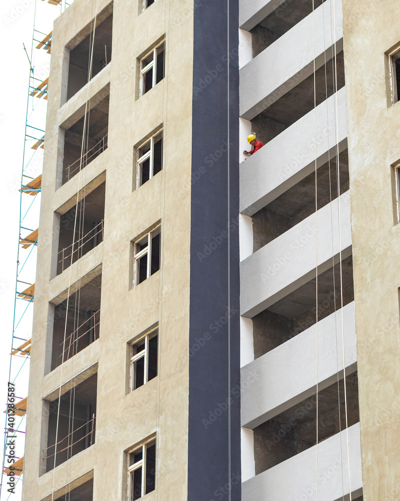 High buildings with scaffold at the construction site, painting a wall