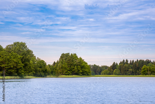 Summer landscape with lake, forest and blue sky clouds