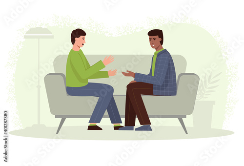 Two men sit on the couch and talk. Friends gossip. Leisure of LGBT couples.