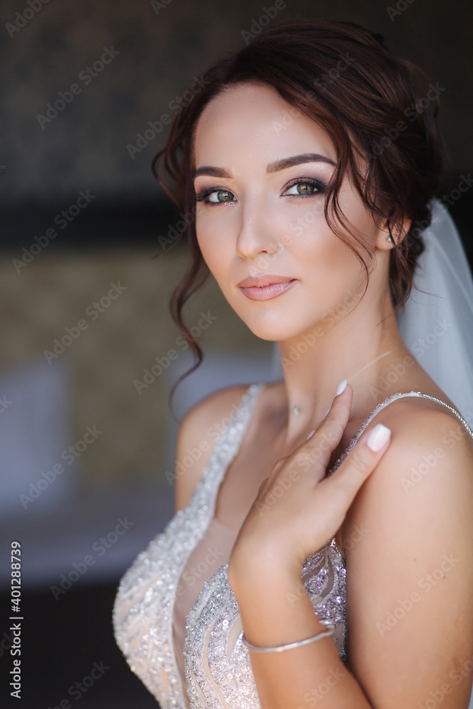 Portrait of elegant bride in fashion wedding dress stand on the balcony and posing to photographer