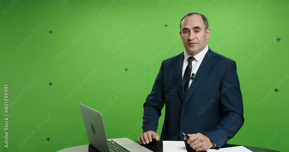 Male television anchor is talking about current news. Serious professional tv channel broadcast news reporter looking at camera. Green background chroma key template 4k footage Male television anchor is talking about current news. Serious professional tv channel broadcast news reporter looking at camera. Green background chroma key template 4k footage