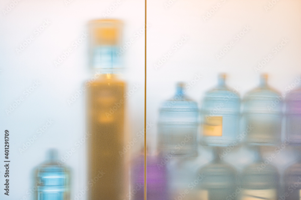 Soft image of plastic water bottles behind glass Soft image of plastic water bottles behind glass
