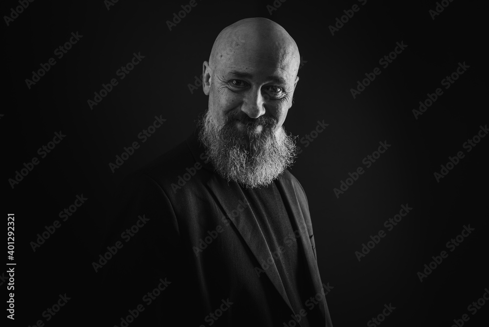 Fototapeta premium close up photo, portrait of a serious, thoughtful, bearded man on a dark background confident and dramatic looking straight. Concept of male portrait. Black and white photo. Low key