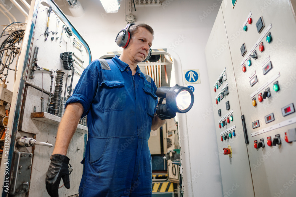 Marine engineer officer controlling vessel enginesand propulsion in engine control room ECR. Ship onboard maintenance Marine engineer officer controlling vessel enginesand propulsion in engine control room ECR. Ship onboard maintenance