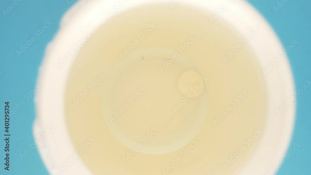 extreme close-up, detailed. pills poured into a jar, top view, blue background. extreme close-up, detailed. pills poured into a jar, top view, blue background.