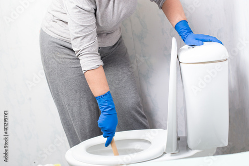 Canvas Print Cleaning stuck in toilet. Woman clean a clogged toilet.