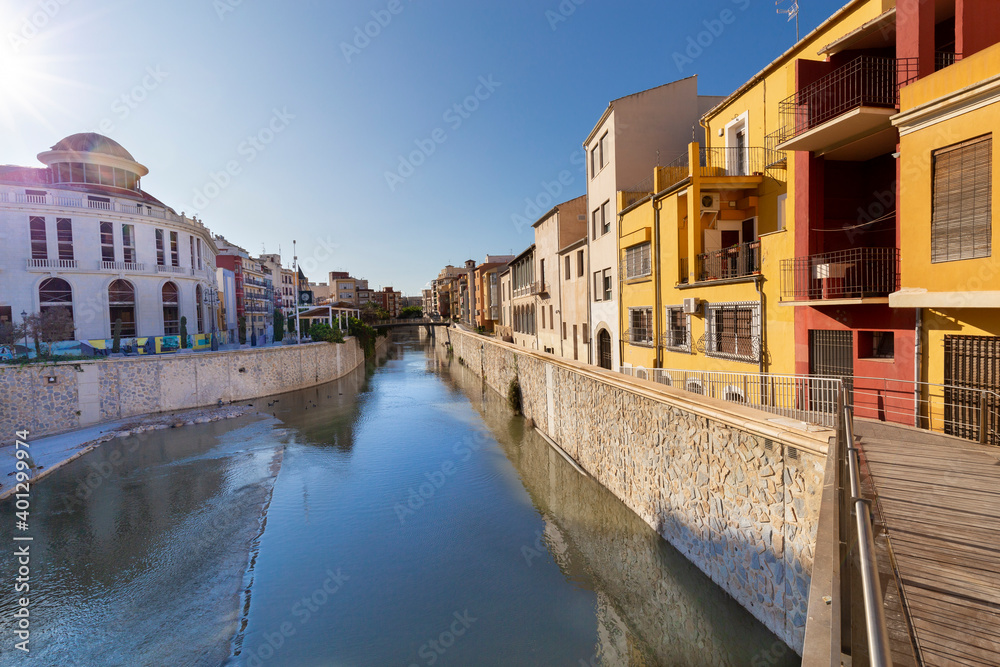 View of the Spanish city of Orihuela on the banks of the Segura river with colorful houses.