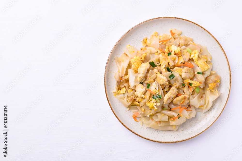 Thai food (Kuaitiao Khua Kai), Stir fried rice noodles with egg and chicken on white background, top view Thai food (Kuaitiao Khua Kai), Stir fried rice noodles with egg and chicken on white background, top view