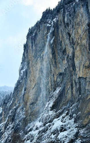Fotografie Huge waterfall falling from a tall, sharp cliff