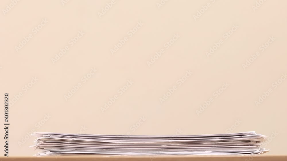 Stack of overload document paper on wooden table - Stop motion animation. Business concept footage.
