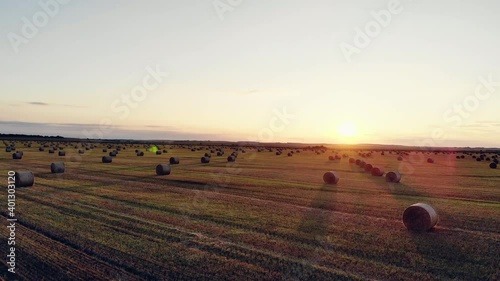 Field with Straw Bales Under Sunset Sky 4k drone Aerilal Shot.Summer harvest fields with straw bales in the evening sunset, agriculture concept, aerial view