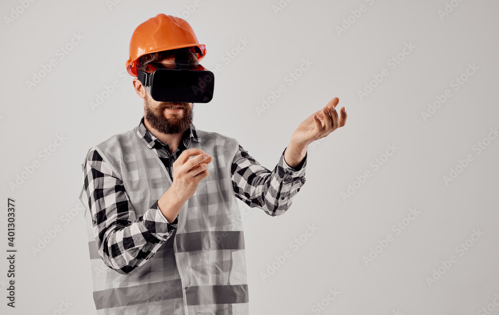 civil engineer in an orange helmet and in 3D glasses on a light background civil engineer in an orange helmet and in 3D glasses on a light background