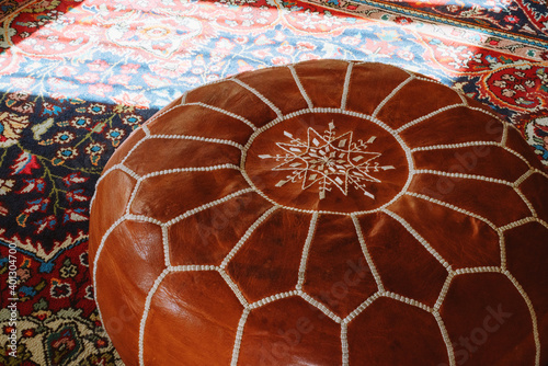 Leather pouf on the traditional carpet