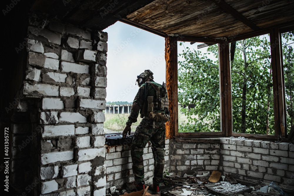 Fototapeta premium The soldier pulls a rifle out of the ammunition case and insert ammunition clip into assault rifle