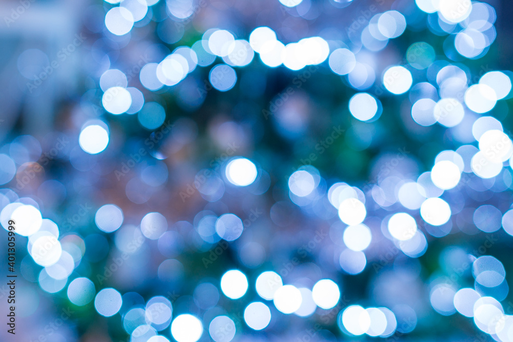 Abstract blue and white bokeh festoon on a dark green background. Bokeh from cold light garland on a Christmas tree. Christmas, New Year festive background. Abstract blue and white bokeh festoon on a dark green background. Bokeh from cold light garland on a Christmas tree. Christmas, New Year festive background.