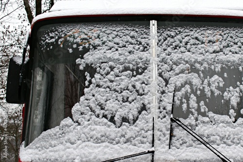 Freshly fallen bright white snow on windshield of the bus
