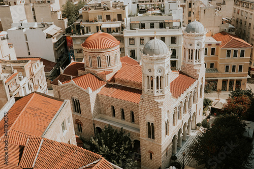 Aerial view of old orthodox cathedral surrouned by old houses in old town of Athens during sunny day. photo