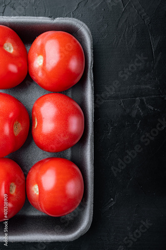 Red tomatoe, on black background with copy space for text