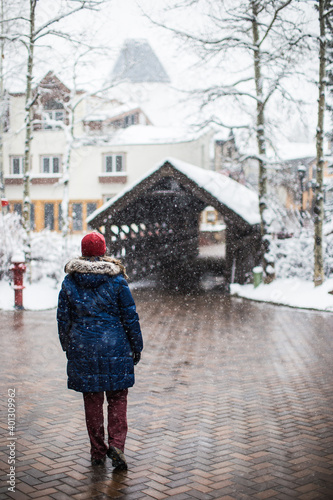 A woman walking into Vail village on a cold, snowy and wintery day in Vail, Colorado, USA