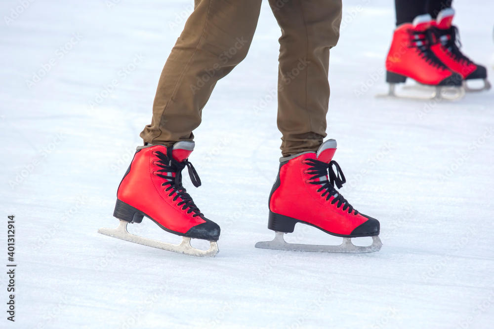 feet in red skates on an ice rink. hobbies and leisure. winter sports feet in red skates on an ice rink. hobbies and leisure. winter sports