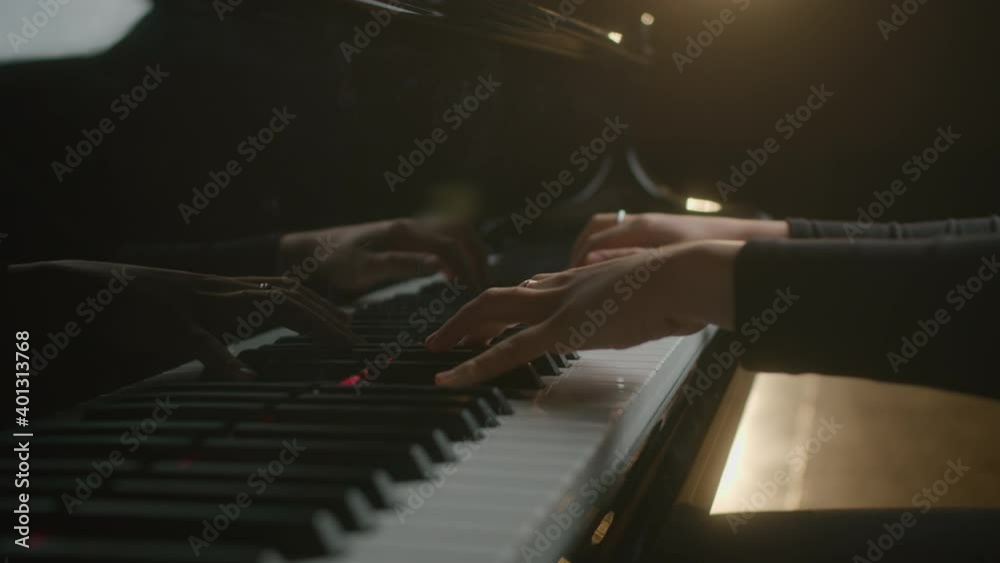 Female pianist plays In Grand Piano On Stage. Black background. Close Up hand.