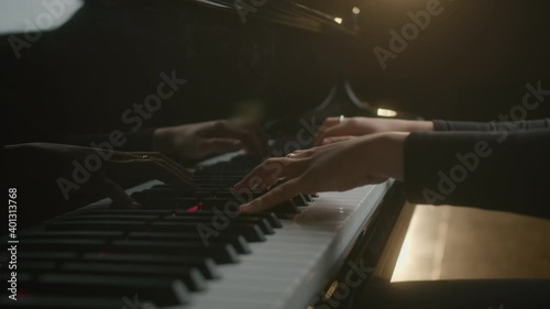 Female pianist plays In Grand Piano On Stage. Black background. Close Up hand. photo