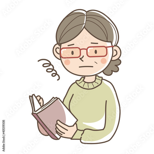 老眼鏡をかけて本を読むシニア女性
