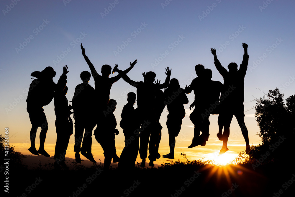 Group many peoples silhouettes jumping in sunset on mountain