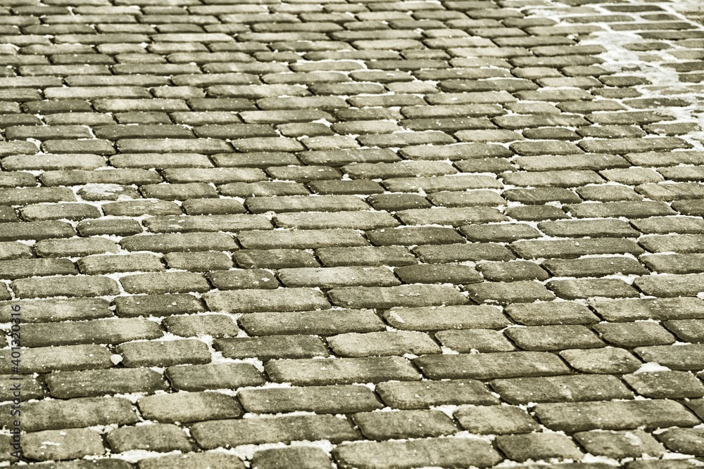 Close up cobblestone pavement in winter time. Textured, surface.